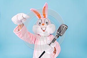 Positive funny man or kid singer or vocalist sings song to retro vintage classic microphone. Easter bunny or rabbit or