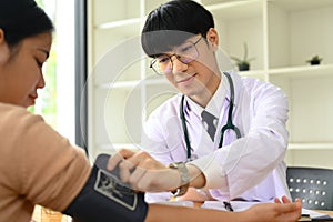 Positive general practitioner in white medical uniform giving consultation, explaining treatment to female patient.