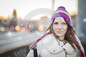 Positive girl with colorfull hat in winter city