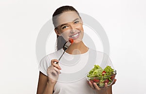 Positive Girl Eating Veggie Salad Smiling Standing In Studio