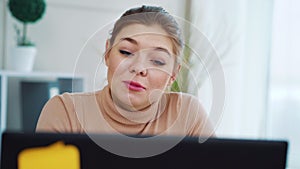 Positive girl having video call on laptop in office