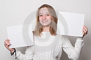 Positive girl holds a blank poster for text.