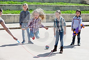 Positive girl jumping while jump rope game