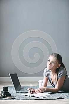 Positive girl with laptop surfing Internet, laying on the floor