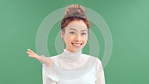 Positive girl promoter point index finger copyspace indicate adverts promotion isolated over green color background