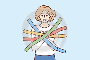 Positive girl smiles happily glued to wall with multi-colored adhesive tapes and is hostage