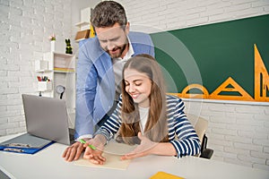 positive girl with teacher in classroom use laptop