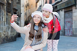Positive girl and woman taking selfie