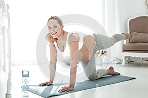 Positive good-looking woman with long ponytail standing on all forth