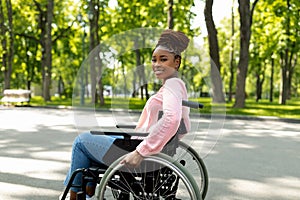 Pozitivní tělesně postižený černý dáma v invalidní vozík těší báječný ráno venku 