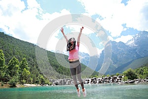 Positive happy life, careless Asian Chinese woman jump by a lake