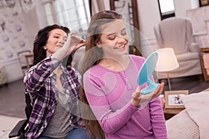 Positive immobile woman taking care of girls hair