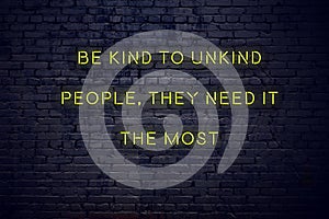 Positive inspiring quote on neon sign against brick wall be kind to unkind people they need it the most