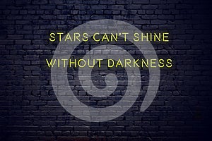 Positive inspiring quote on neon sign against brick wall stars cant shine without darkness
