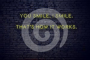 Positive inspiring quote on neon sign against brick wall you smile i smile thats how it works photo