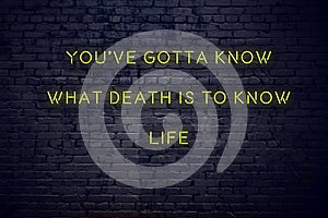 Positive inspiring quote on neon sign against brick wall youve gotta know what death is to know life