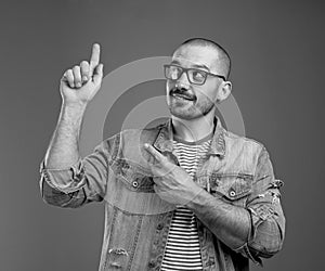 Positive intelligent man pointing his forefingers upwards with interest photo