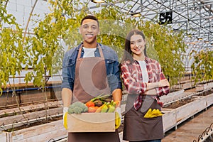 Positive interracial famers in aprons holding