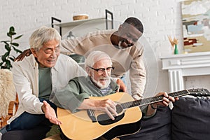 Positive interracial pensioners looking at friend