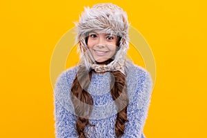 positive kid with curly hair in earflap hat. female fashion model. teen girl in knitwear