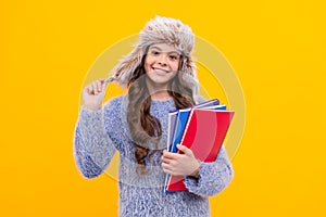 positive kid with curly hair in hat. back to school. teen girl in knitwear on yellow background