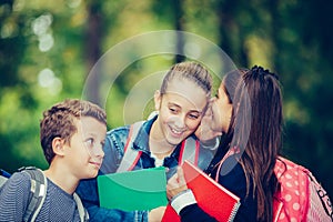 Positive kids whispering a secret each other in the ears