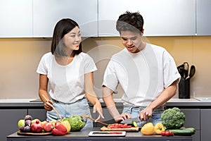 Positive Korean Husband And Wife Preparing Dinner Cooking Together Indoors