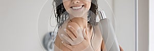 Positive lady with shiny smile showering in bathroom advertizing shampoo photo