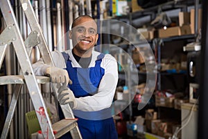 Positive Latin American workman in wareroom of construction hypermarket
