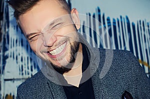 Positive laughing man with a white tooth smile on the background