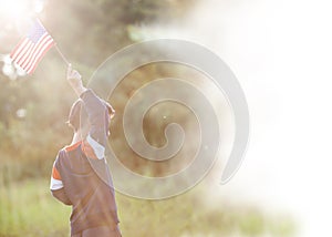 Positive little boy with american flag and celebrating 4th of july, independence day, or memorial day.