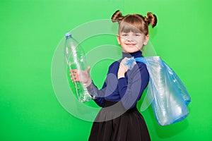 Positive little ecologist girl holding trash bag with plastic bottles and show thumb up isolated on green background