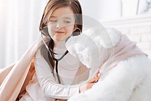 Positive little girl pretending to be a doctor