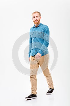 Positive male with beard walking and looking camera