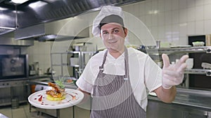 Positive male chef gesturing gusto gesture looking at camera smiling bragging cooked prawn served on plate. Portrait of