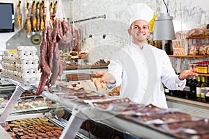 Positive male seller working at meat market