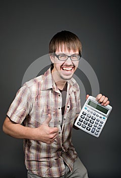 Positive man with calculator on grey