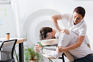 Masseuse doing arm massage for businessman