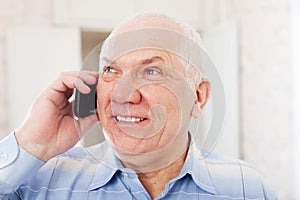 Positive mature man speaks by phone