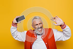 positive middle aged man holding cellphone