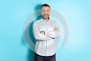 Positive Middle Aged Man Posing Crossing Hands Over Blue Background