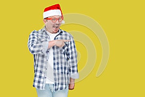 Positive middle aged man in red new year santa cap and casual st