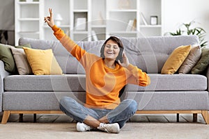 Positive millennial eastern woman enjoying her favorite music