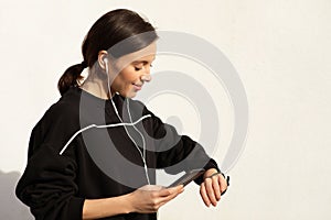 Positive millennial european woman athlete in sportswear and headphones enjoy music and workout