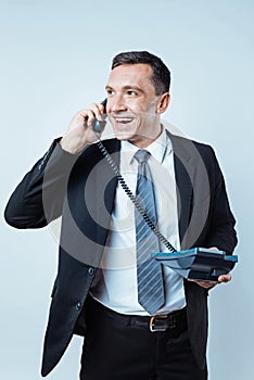 Positive minded man having pleasant telephone conversation