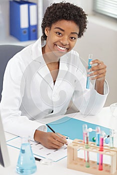 positive minded woman smiling while looking at test tube