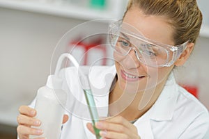 positive minded woman smiling while looking at test tube