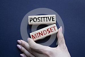 Positive Mindset symbol. Concept words Positive Mindset on wooden blocks. Businessman hand. Beautiful deep blue background.