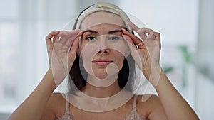 Positive model facial treatment at home mirror pov portrait. Woman face massage