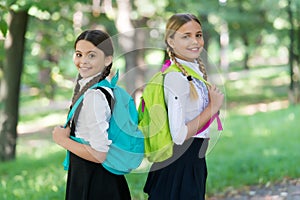 Positive mood. teenage girls with backpacks walking in park. Back to school. Teen kids with backpack. concept of